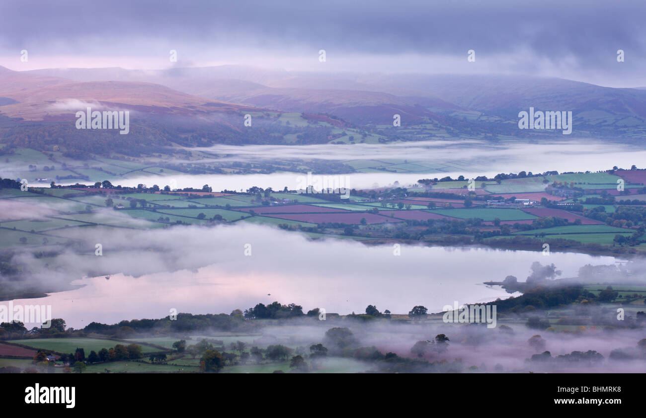 Llangorse Lake and the Brecon Beacons mountain range at dawn on a misty morning, Brecon Beacons