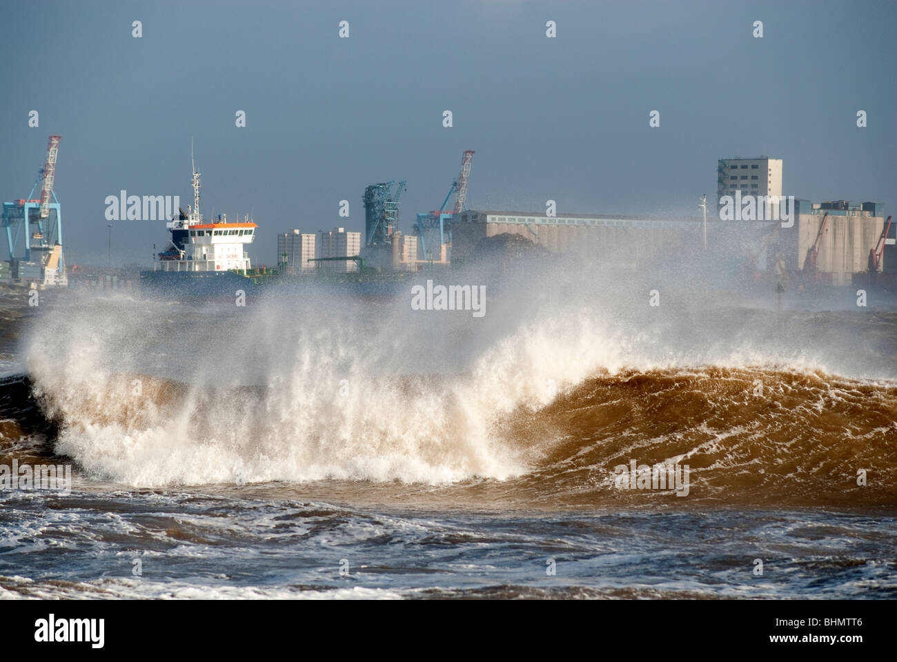 Huge waves on River Mersey obscuring container shipping vessel Stock Photo