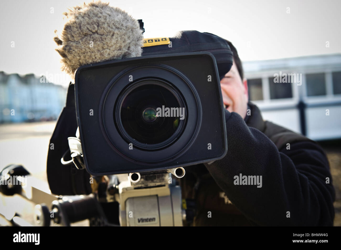 tv film crew recording news item - close up of video camera lens and cameraman Stock Photo