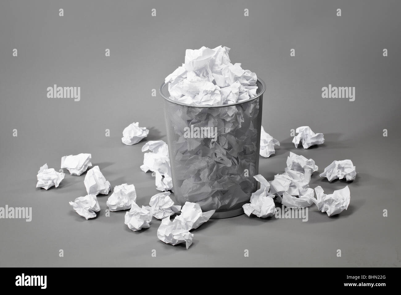 A trashcan filled with crumpled white papers Stock Photo