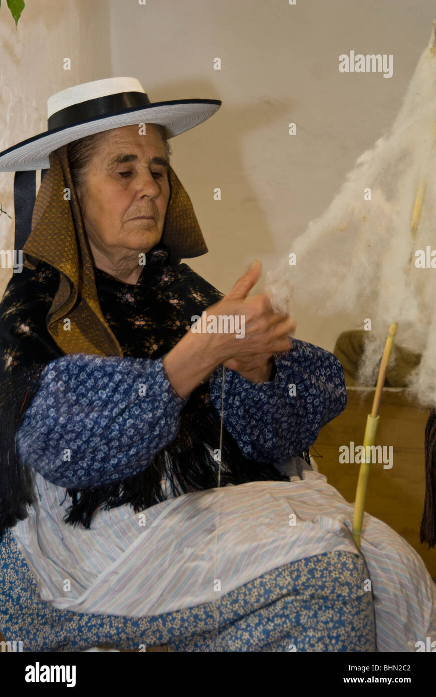 Elderly woman in traditional costume spinning wool, Ibiza, Spain Stock Photo