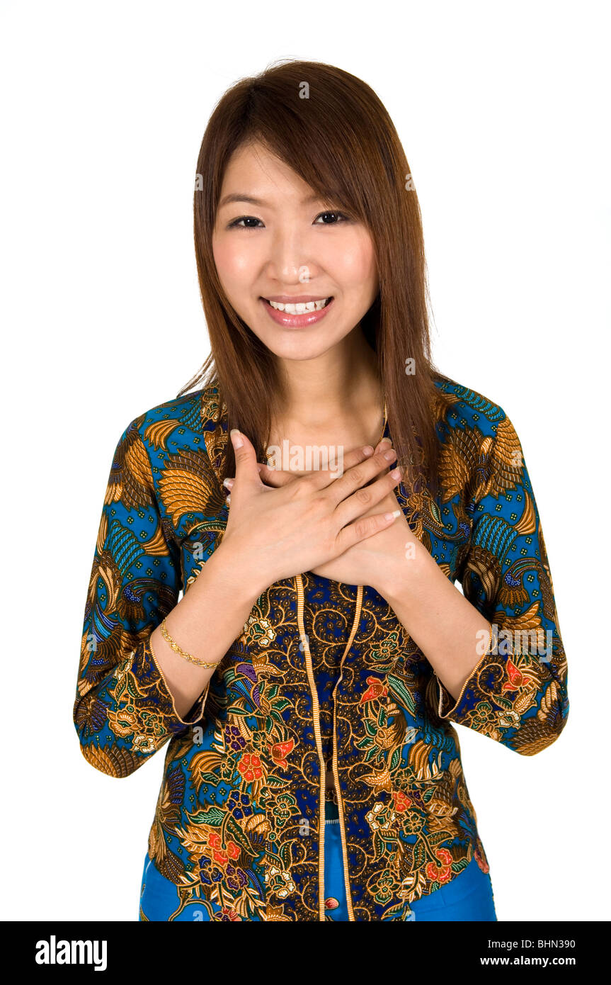 Malaysian girl wearing batik kebaya with hand on chest Stock Photo