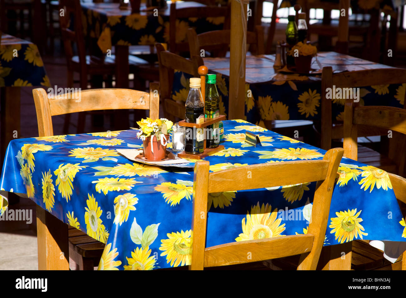 Wooden chairs and table with blue and yellow floral cloth outside