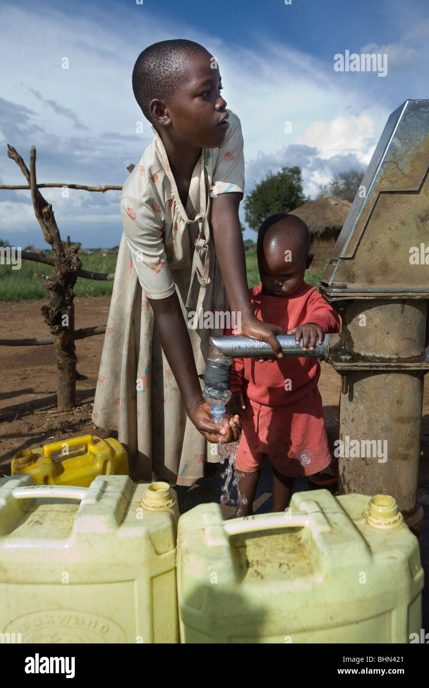 Children fetch fresh drinking water at a borehole in Amuria District, Teso Region, Uganda. Stock Photo
