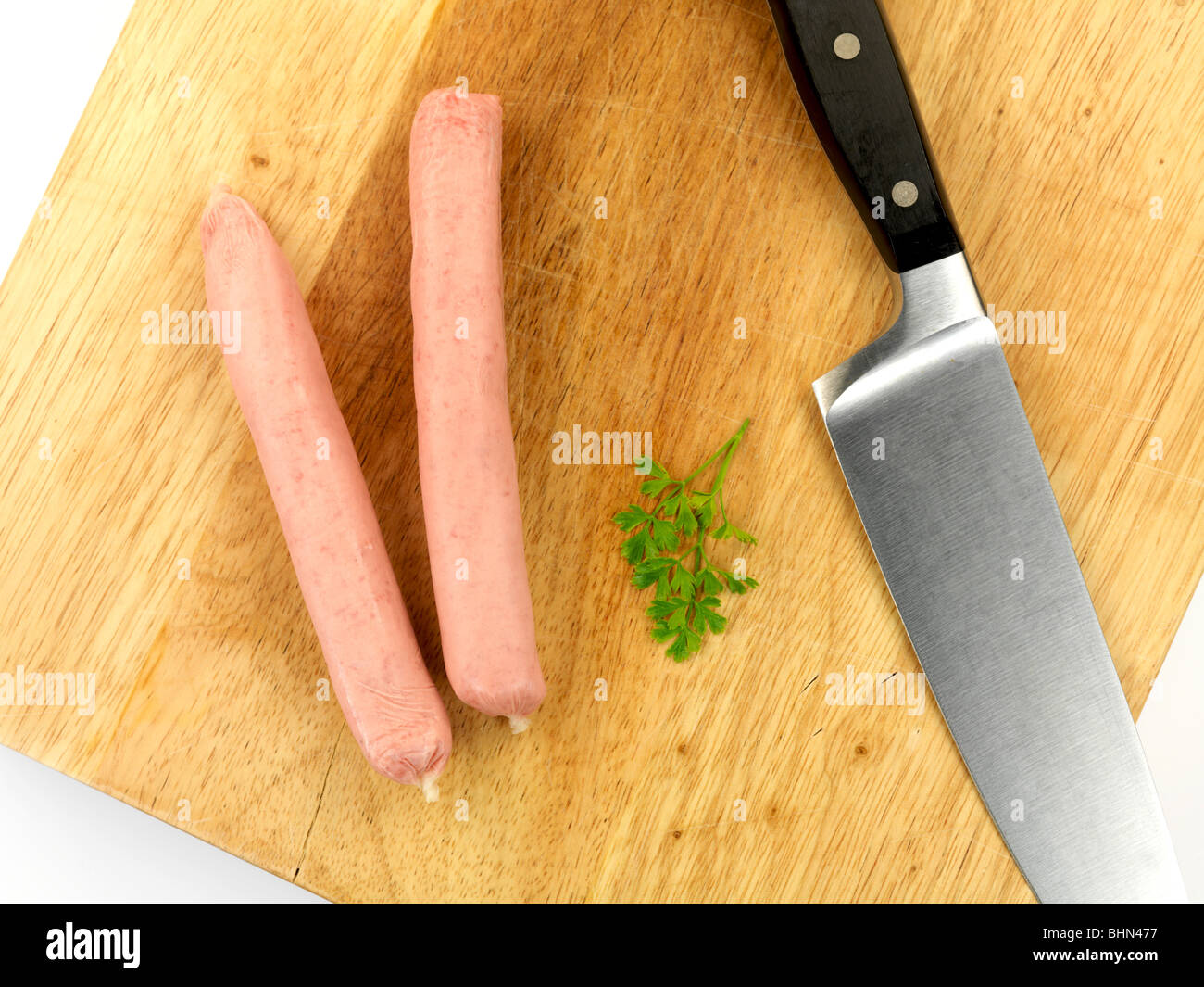 Pork Sausages on a chopping board isolated against a white backgroun ...