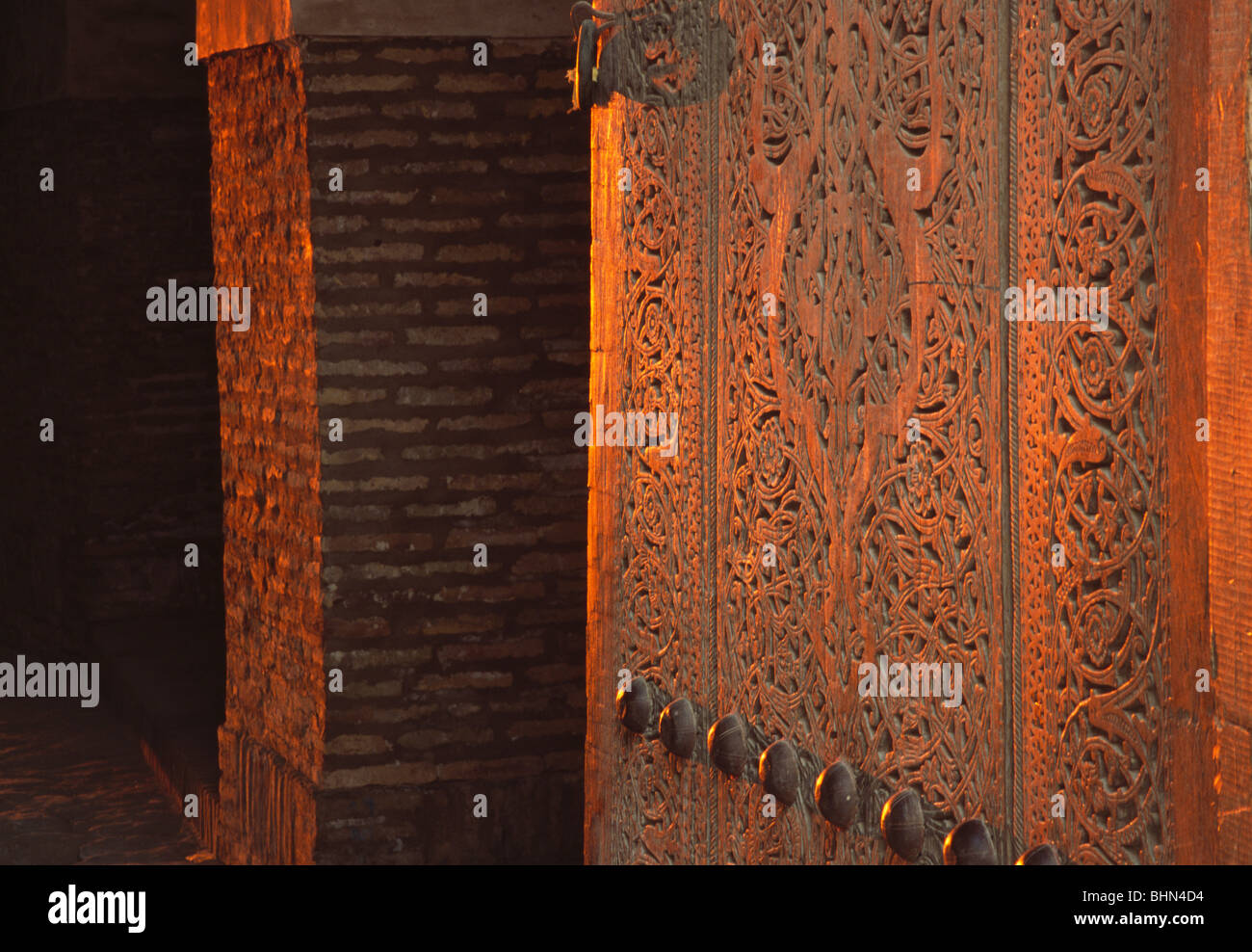 Sunset view of intricately carved wood doors at East Gate to wallked inner city of Ichon-Qala-Khiva, Uzbekistan Stock Photo