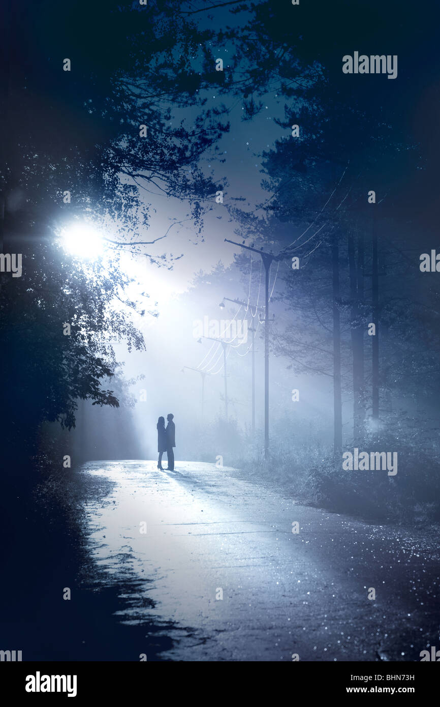 silhouette couple stand together in the moonlight Stock Photo