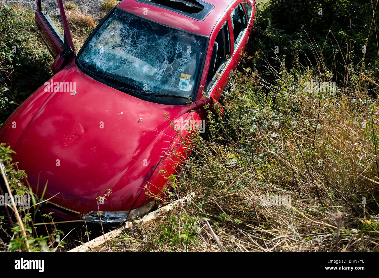 Abandoned car dumped in ditch and deliberately damaged Stock Photo Alamy