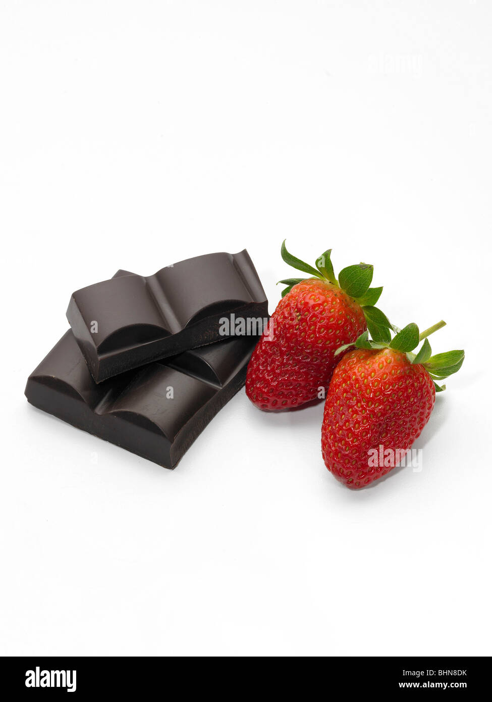 Plain Chocolate Chunks and Two Strawberries on White Background Stock Photo