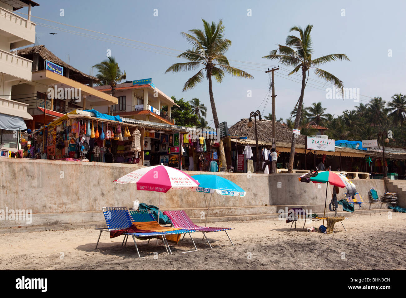 India, Kerala, Kovalam, sunlougers on Lighthouse (Adam) Beach, with new seafront development behind Stock Photo