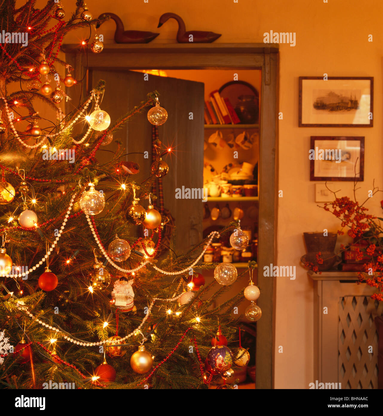 Christmas tree beside open door in traditional living room Stock Photo ...