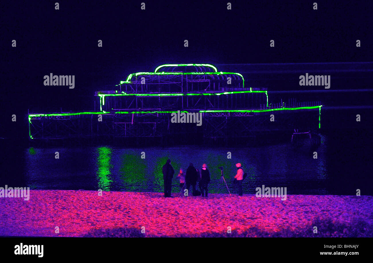 The West Pier in Brighton lit up by a laser show UK Stock Photo