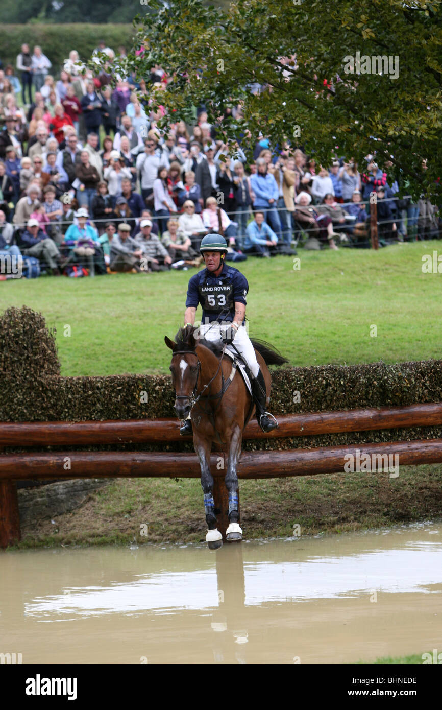 HORSE AND JOCKEY AT WATER JUMP ON THE CROSS COUNTRY COURSE AT BURGHLEY HORSE TRIALS Stock Photo