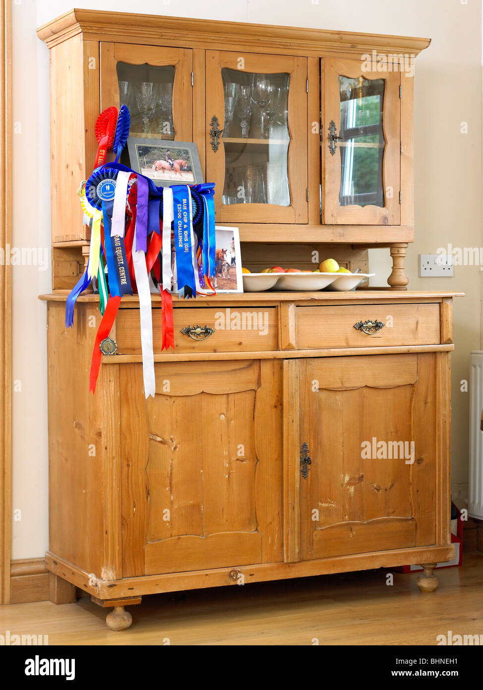 A Kitchen Dresser With Horse Riding Rosettes On It Stock Photo