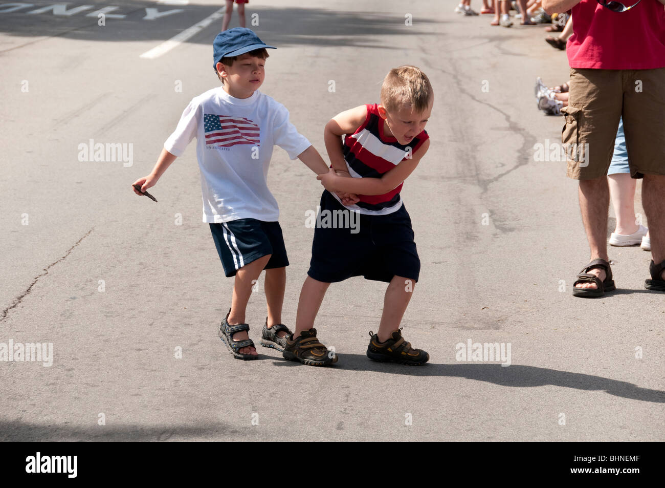 Children crossing street, waiting for parade. Stock Photo