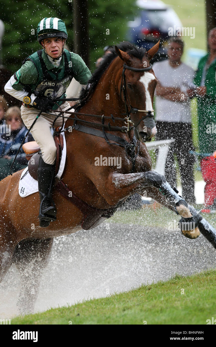 HORSE AND JOCKEY AT WATER JUMP ON THE CROSS COUNTRY COURSE AT BURGHLEY HORSE TRIALS Stock Photo