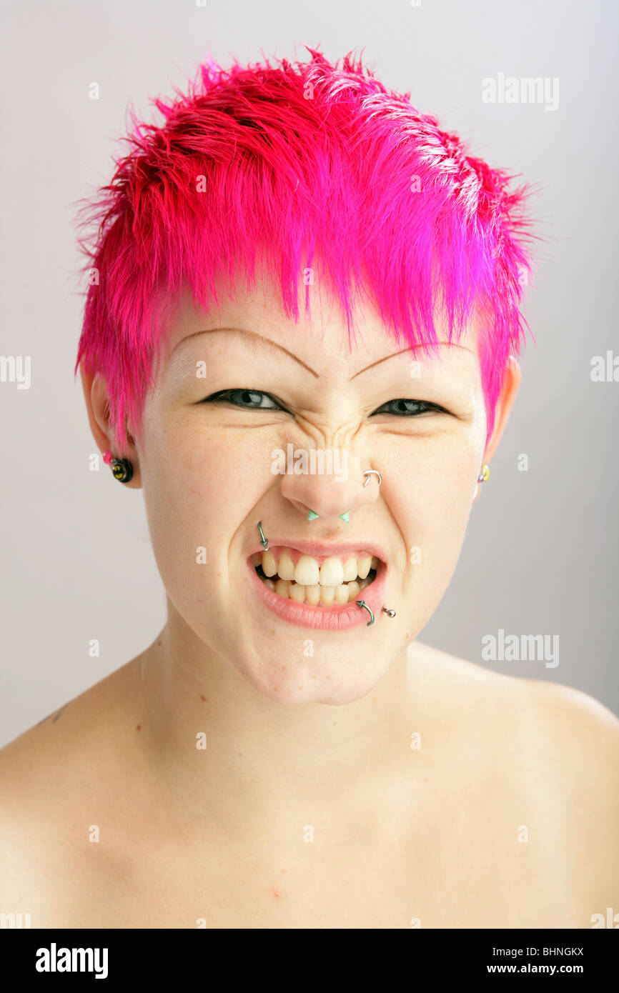 Woman with brightly coloured hair snarling towards camera. Stock Photo