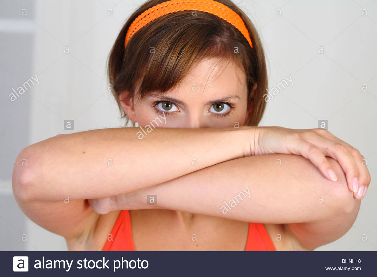 portrait brunette woman covering her face with arms Stock Photo