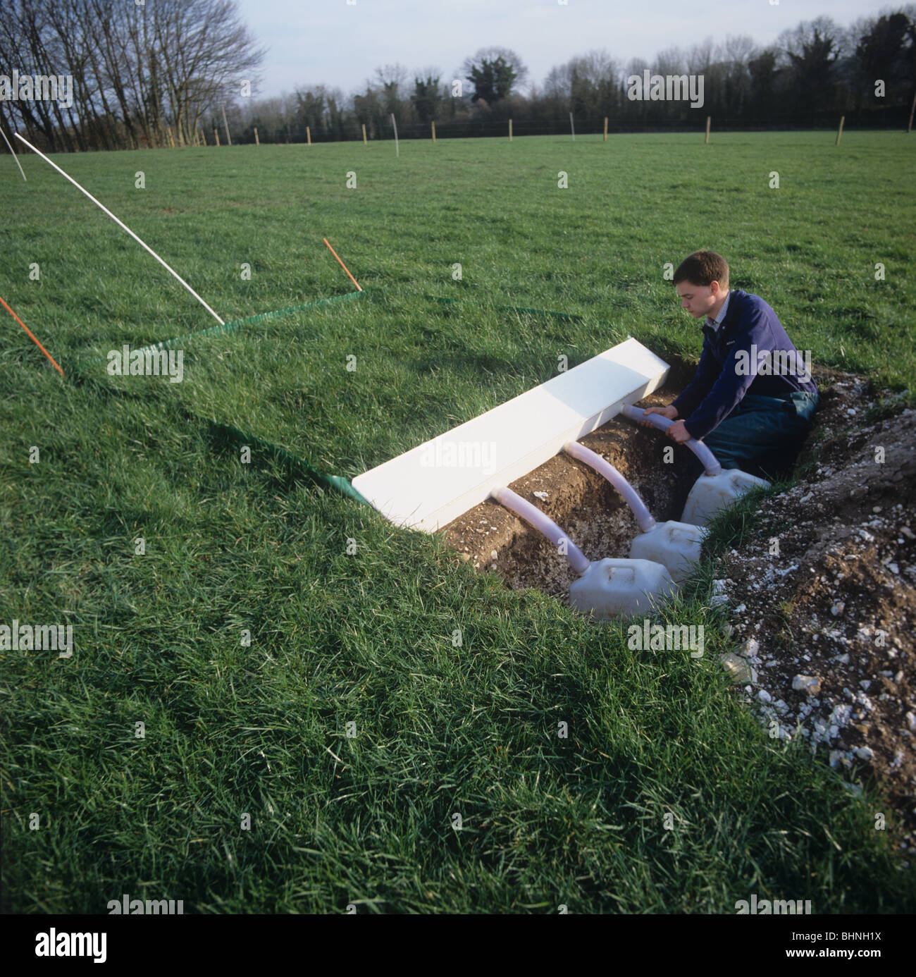 Collection bottles to monitor erosion of sediment from a grass plot Stock Photo