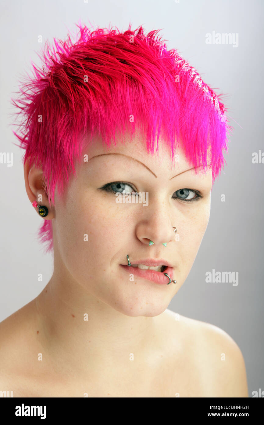 Pretty woman with brightly coloured hair bite her lip. Stock Photo
