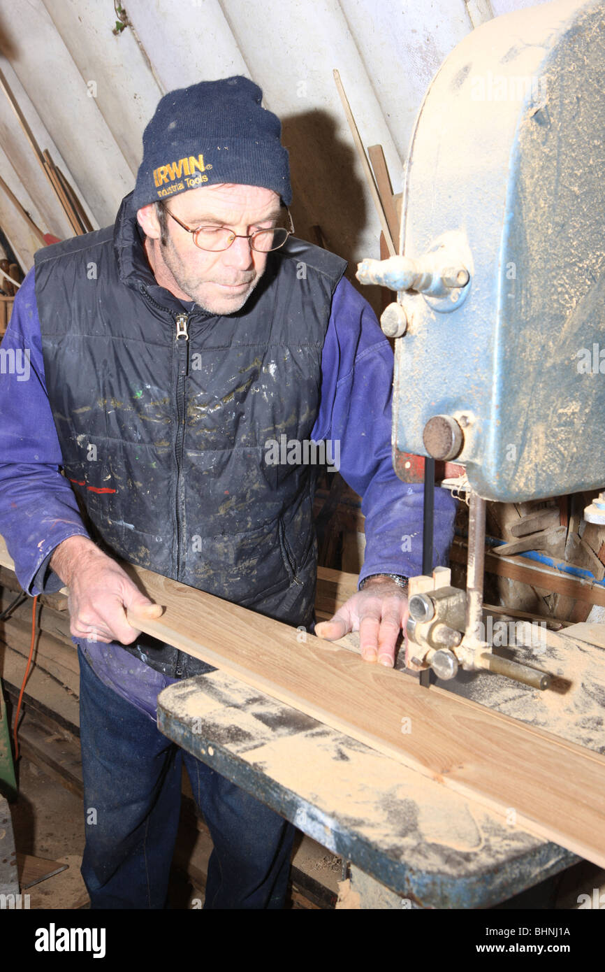 Boat builder Dave Currah using a Band Saw in his workshop at Looe Cornwall, he makes the traditional cornish Pilot Gigs, Stock Photo