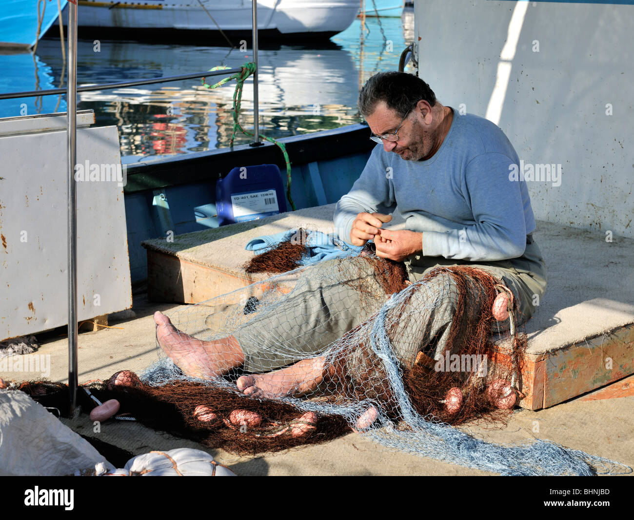 Maltese man mending fishing net, Gozo Stock Photo