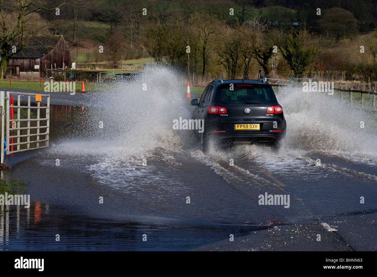 VW Motor Vehicle travelling at speed through flooded grounds in Derbyshire near Bakewell Stock Photo