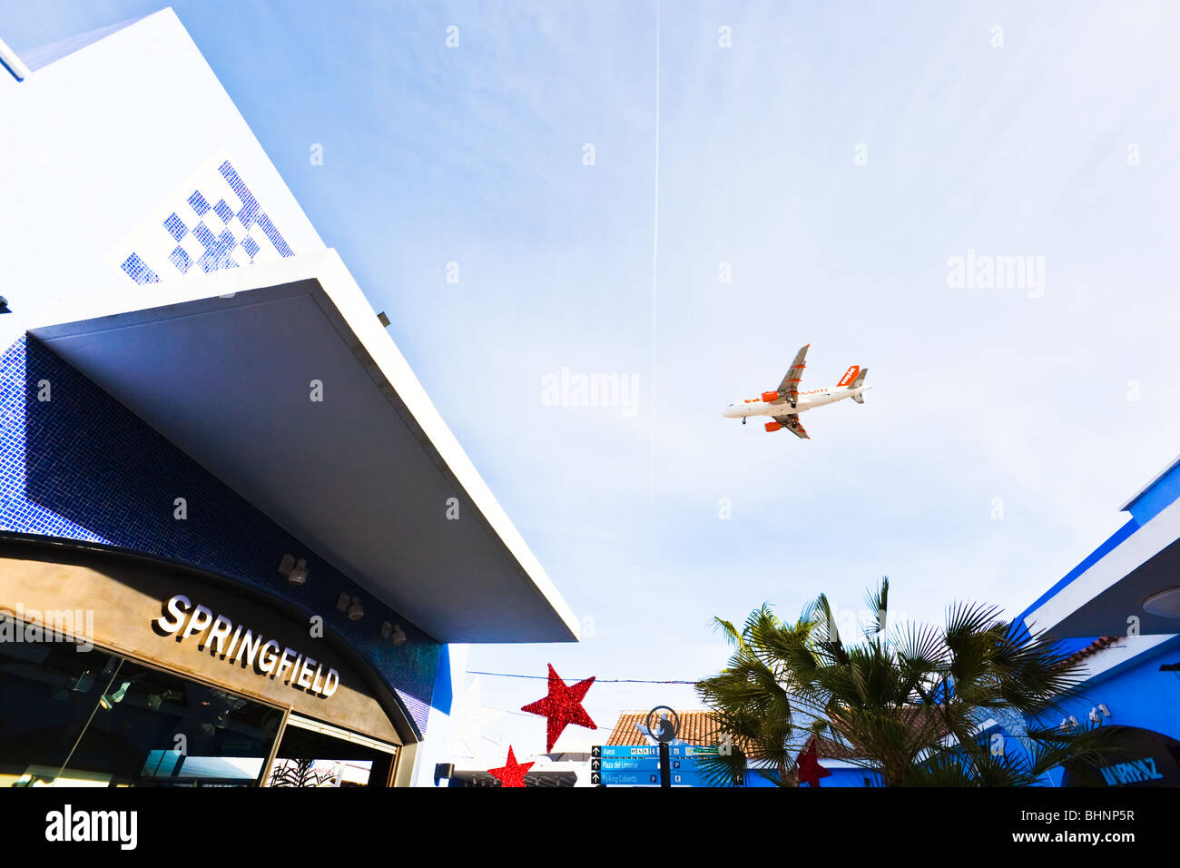 EasyJet aeroplane flying over Plaza Mayor shopping centre, Malaga, Costa del Sol, Spain. Springfield shop in foreground. Stock Photo