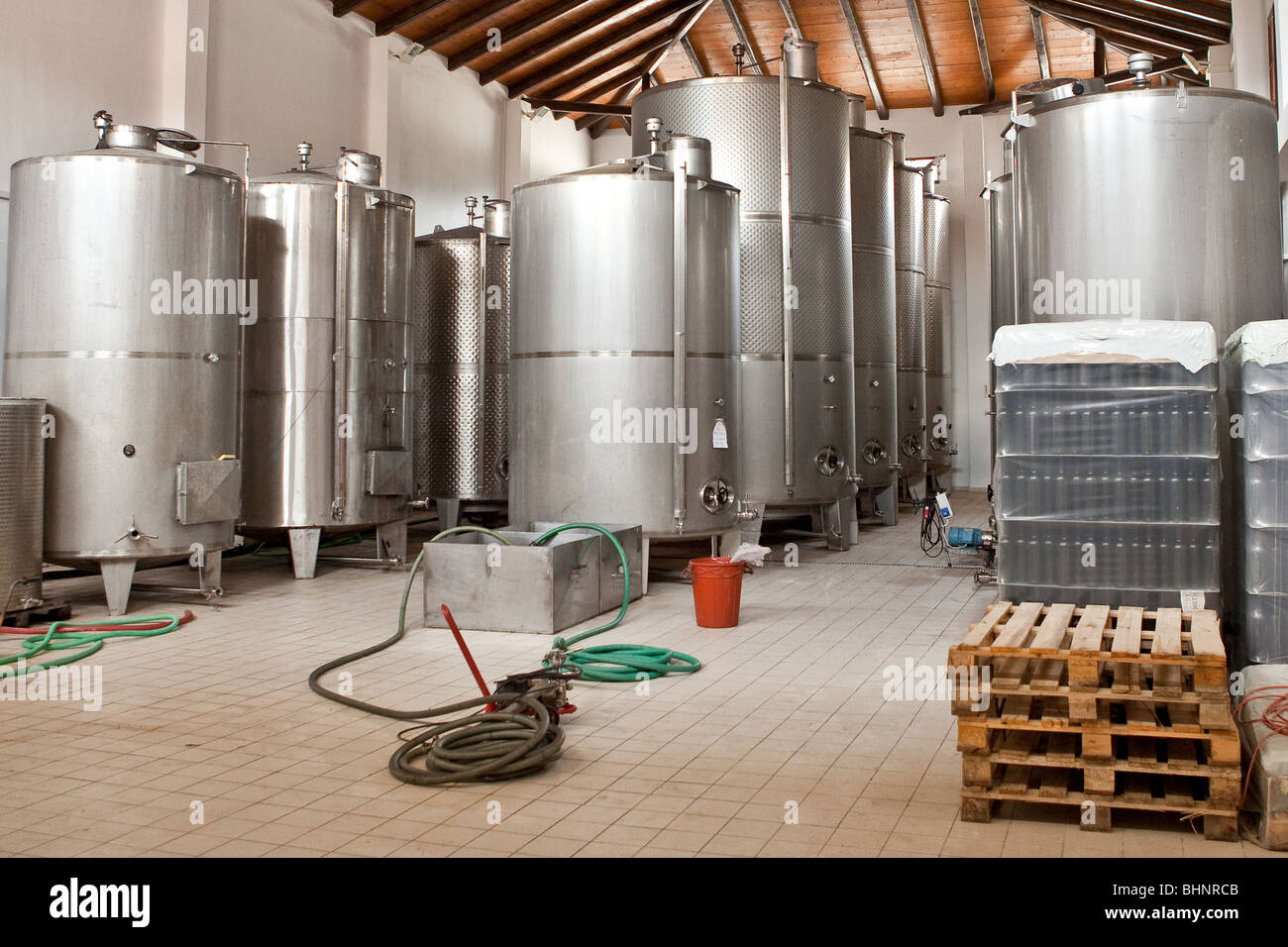 Wine Fermenting in huge vats in a wine cellar. Shoot in Greece Stock