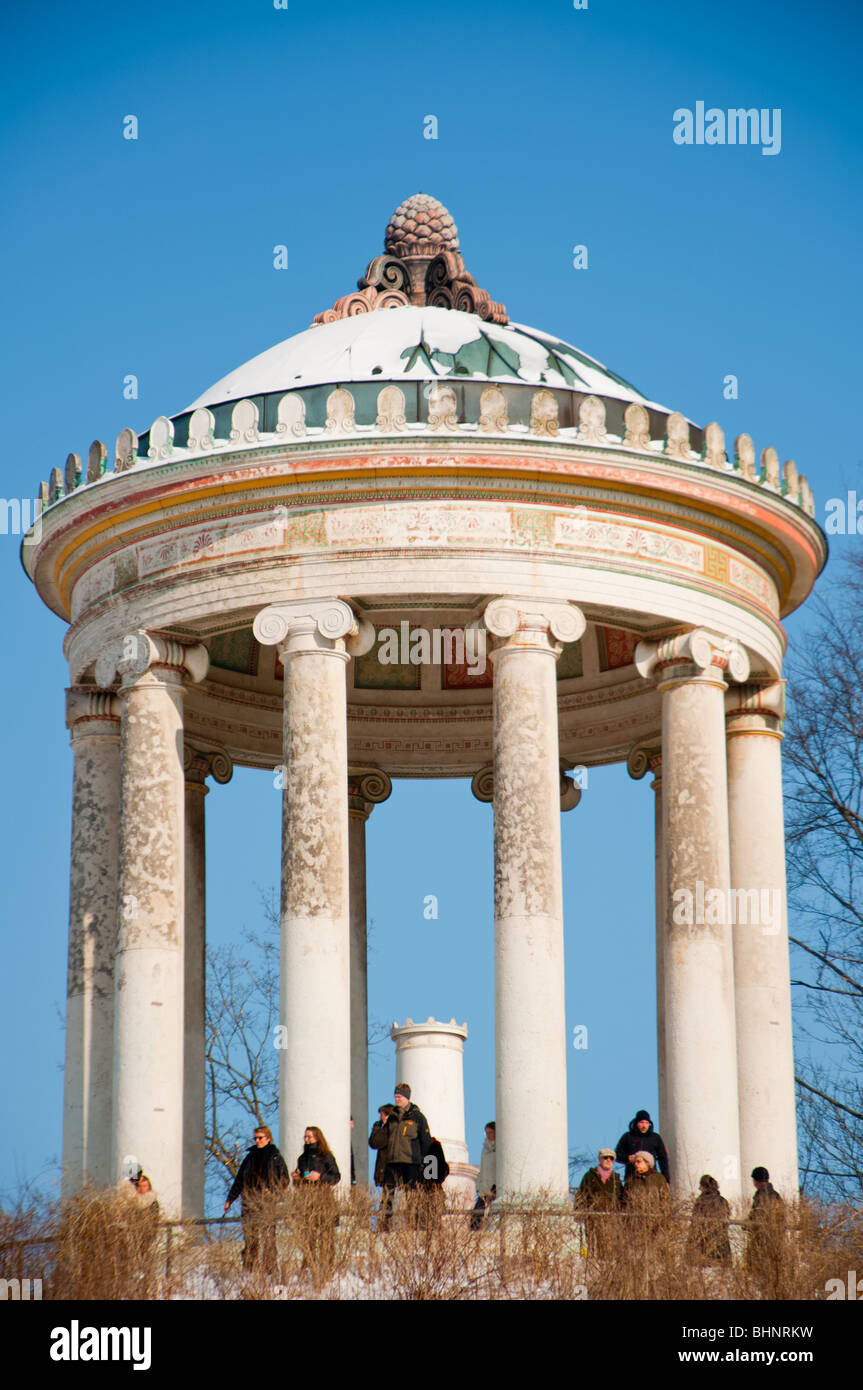 Visitors enjoy the view from a snow covered Monopteros in the English garden, Munich, Germany. Stock Photo