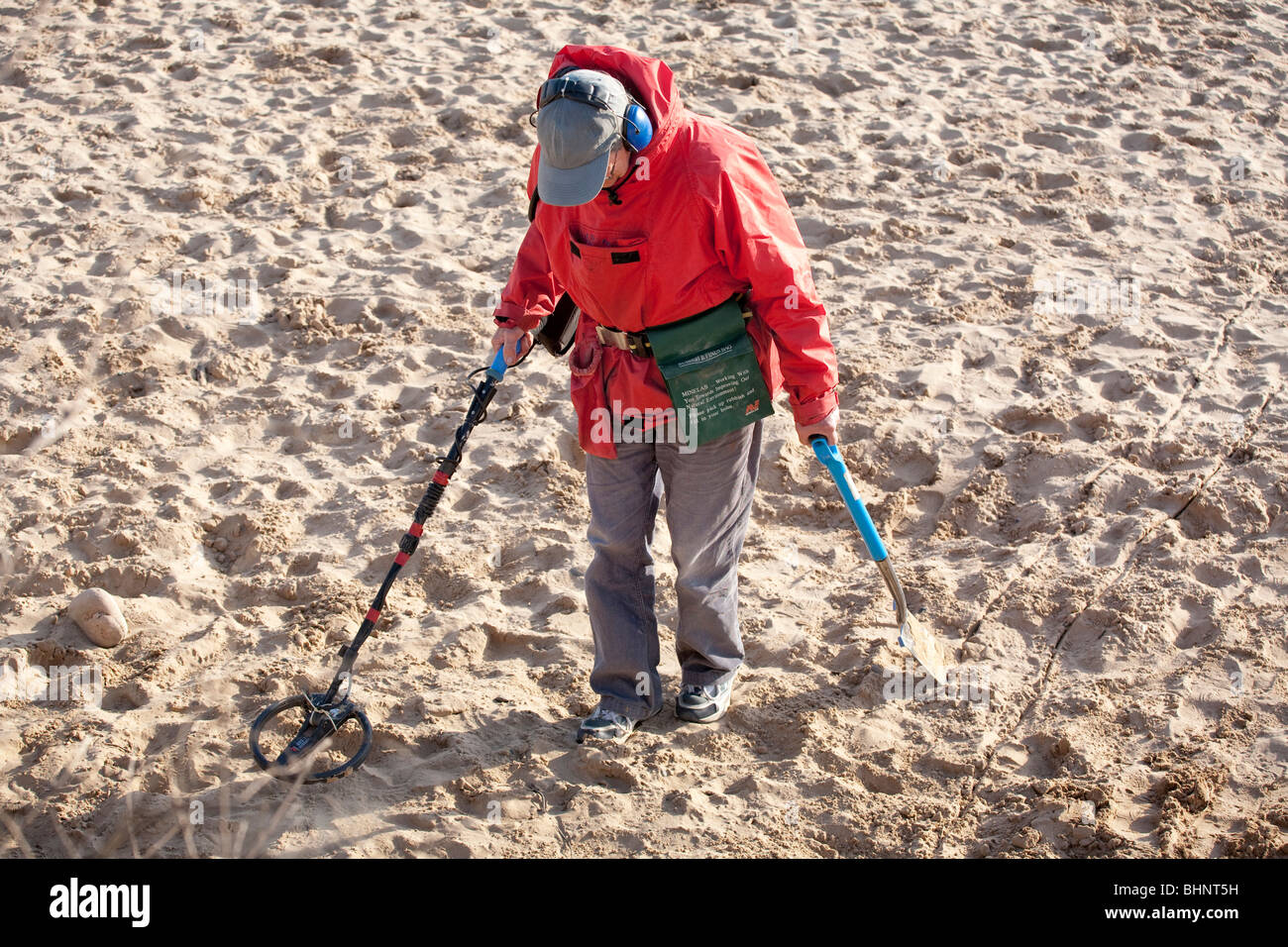 searching a sandy beach with a metal detector Stock Photo