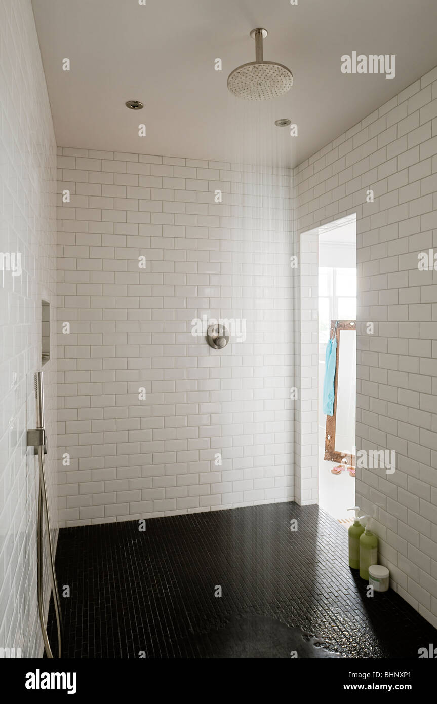 Walk-in shower room with white running-bond tiled walls Stock Photo