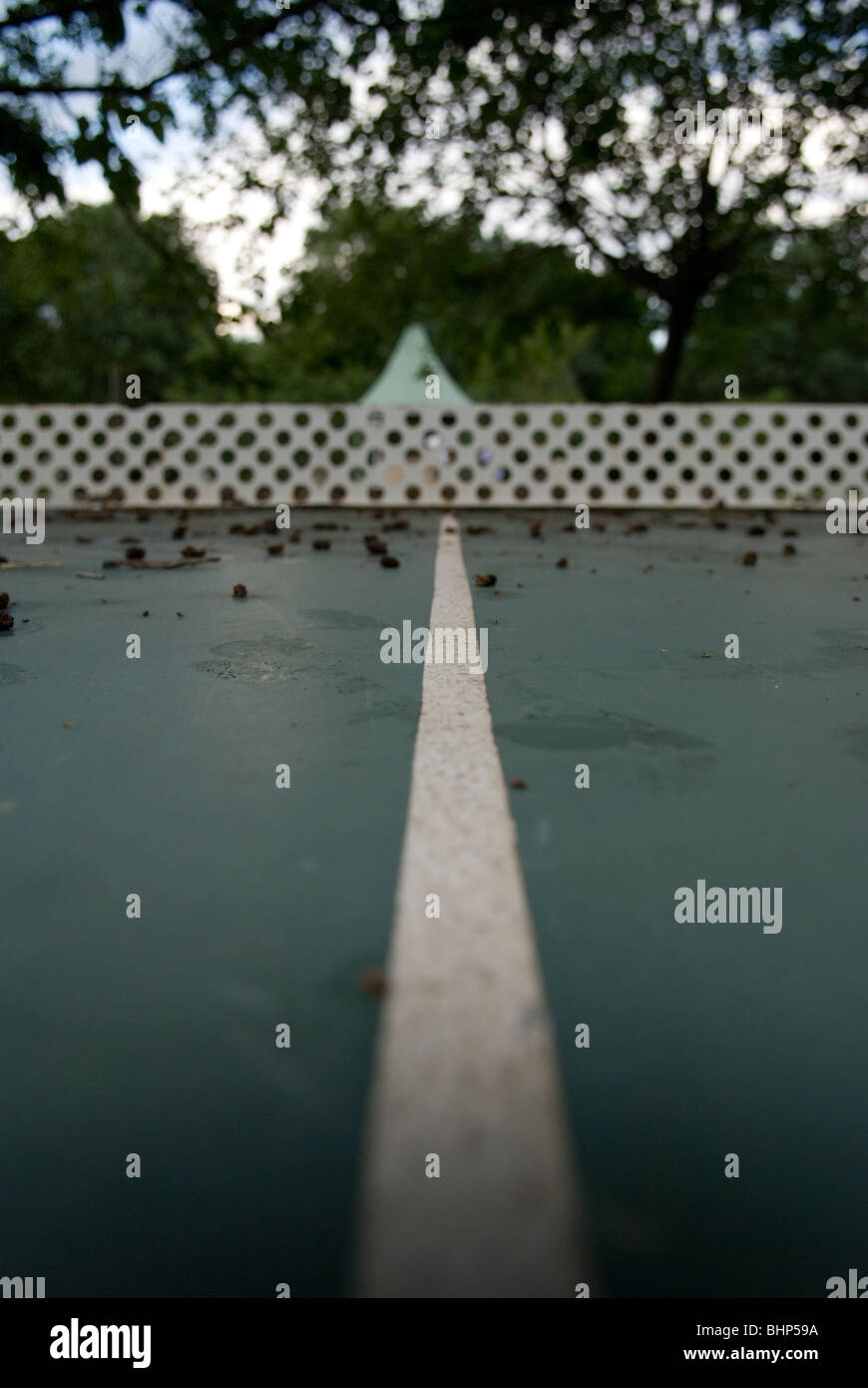 close up view of outdoor ping pong table covered with vegetation on a campsite in france Stock