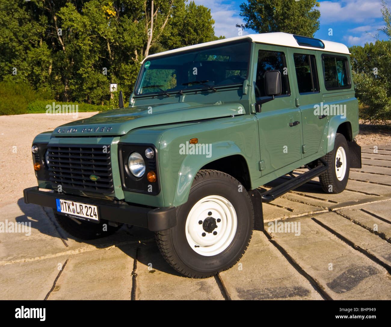 Front view with radiator of classical Land Rover Defender 110 off road four  wheel drive car, 2008 model with trees Stock Photo - Alamy