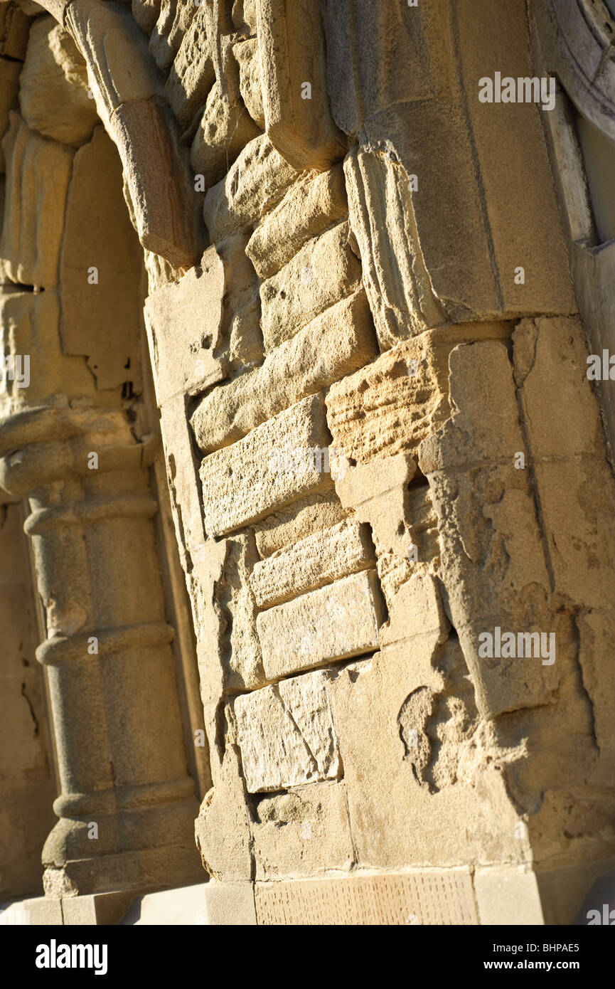 Heavily weathered eroded damaged worn-down sandstone blocks on a building, UK Stock Photo