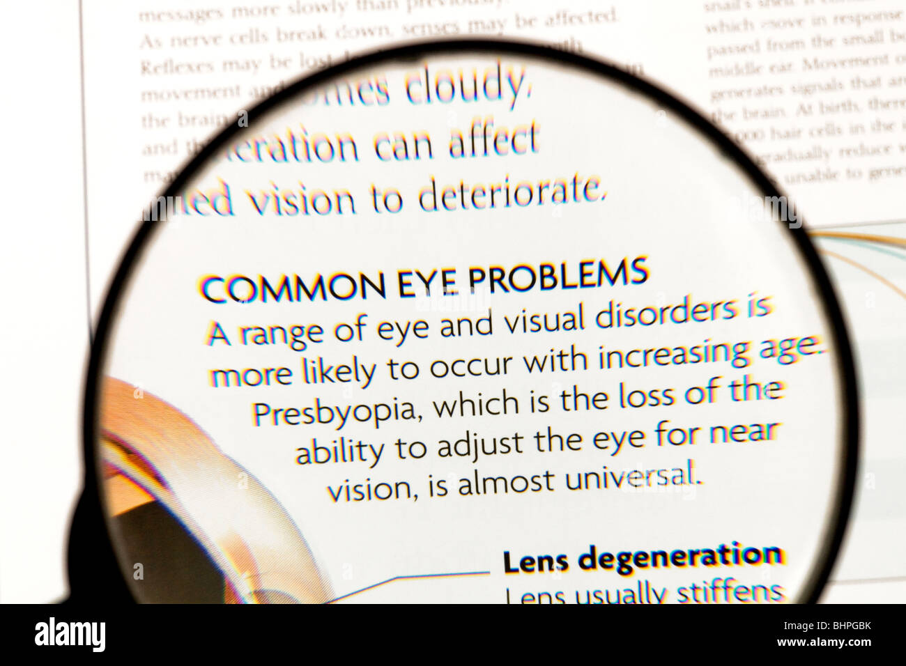 Someone using a magnifying glass to read about eye problems. The text is not my copyright Stock Photo