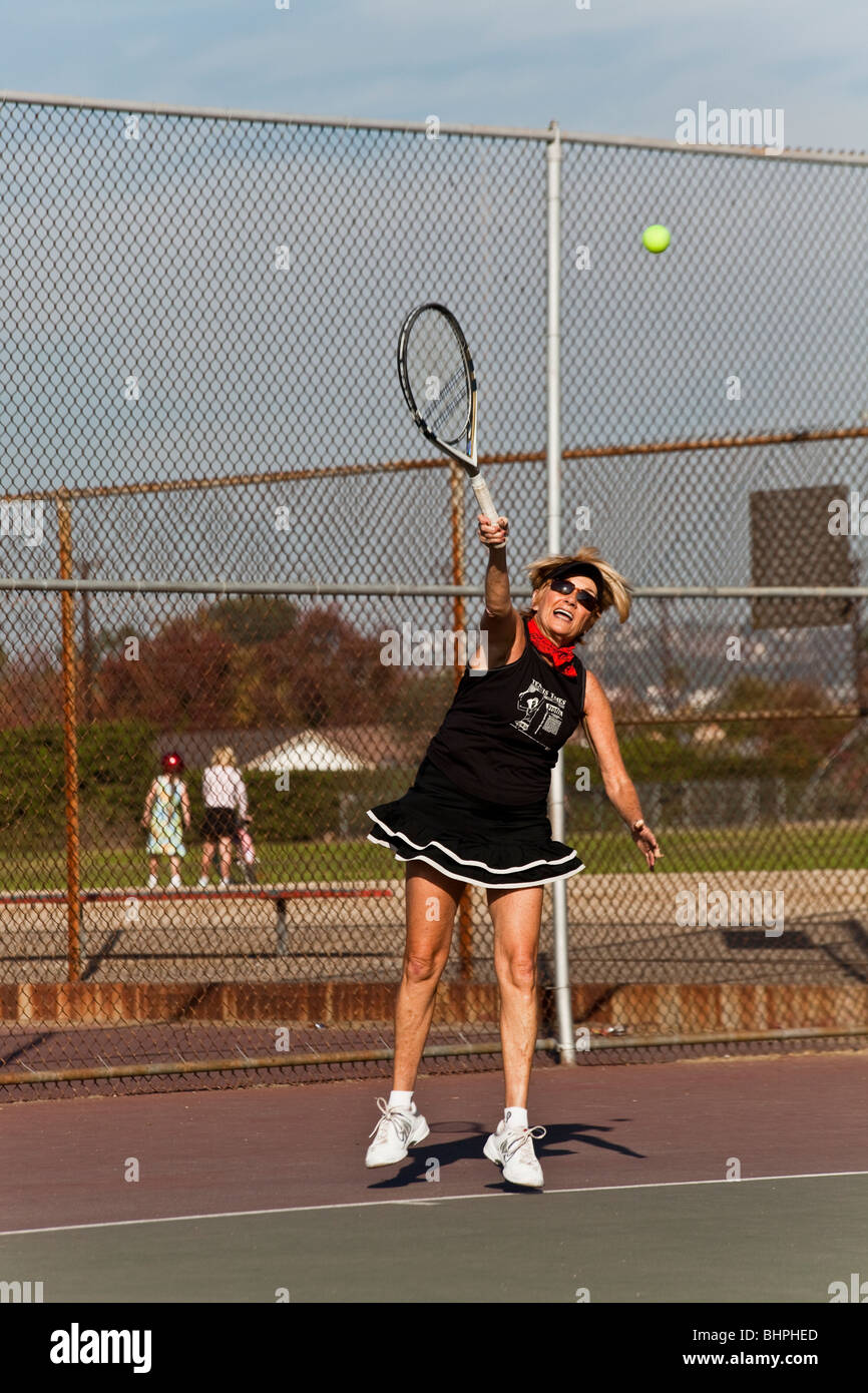 Senior woman in her 70s playing tennis in public park. MR  © Myrleen Pearson Stock Photo