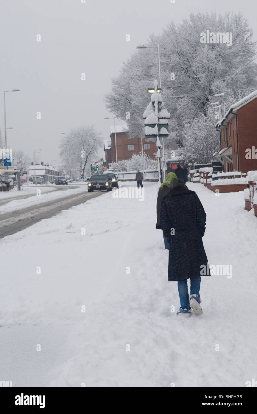 People walking in a severe snow storm in Manchester UK Stock Photo