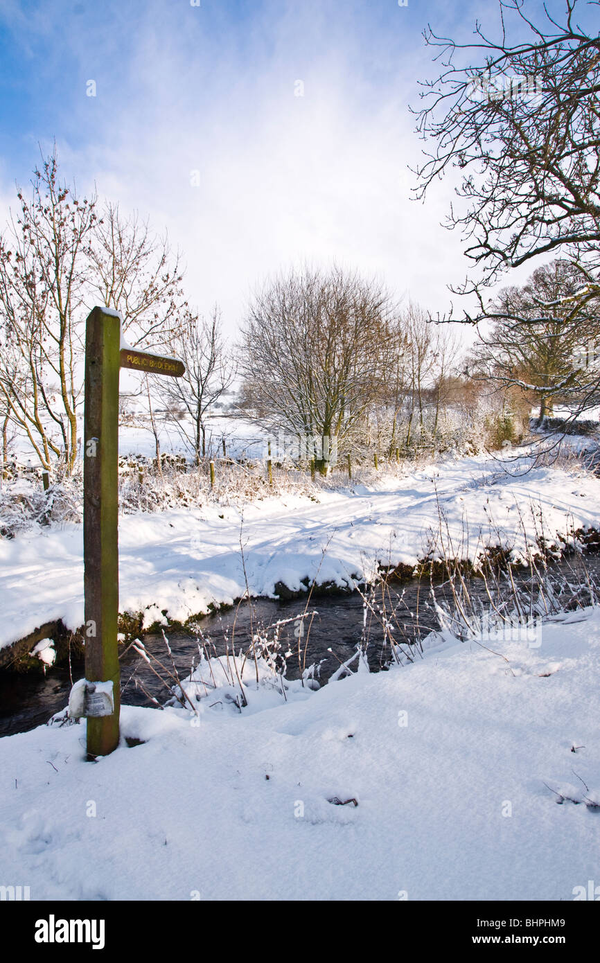 Footpath sign and snow covered green lane at Bellerby in North Yorkshire Stock Photo