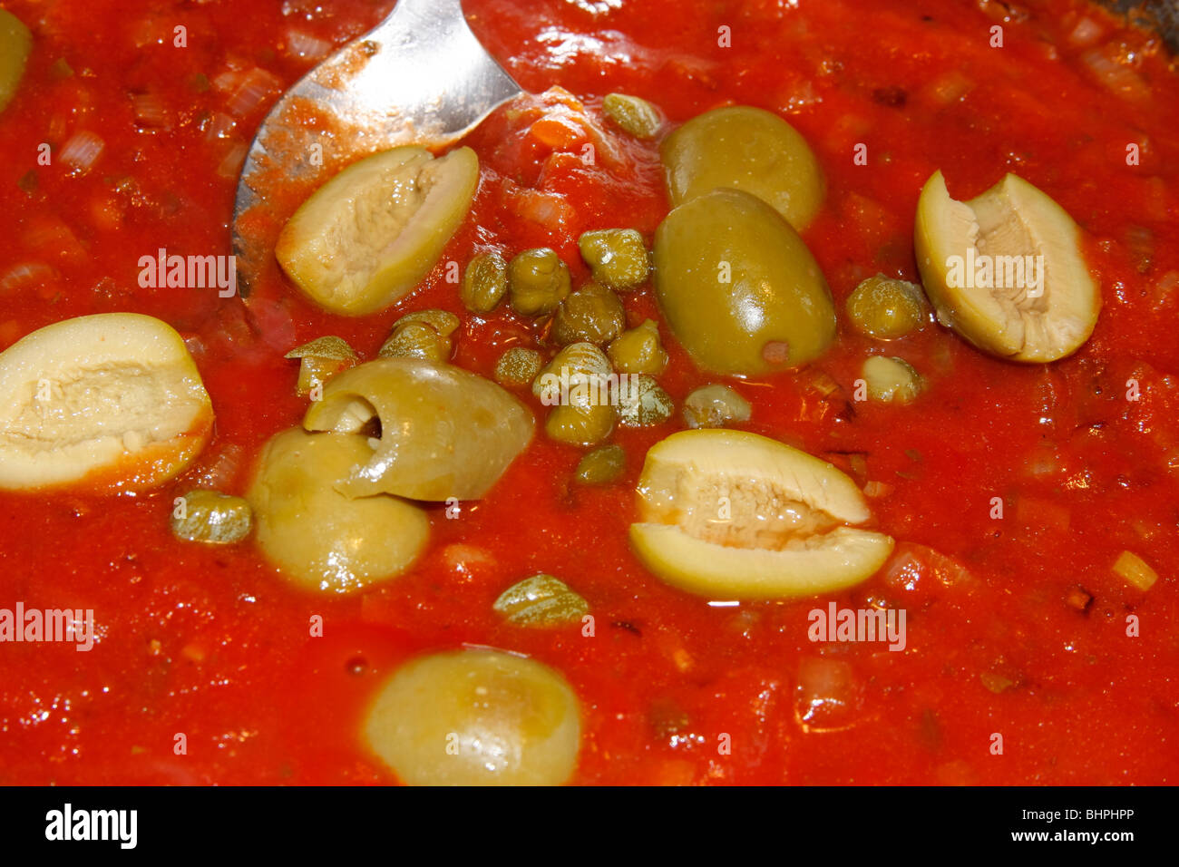 cooking italian tomato sauce with olives and capers Stock Photo Alamy