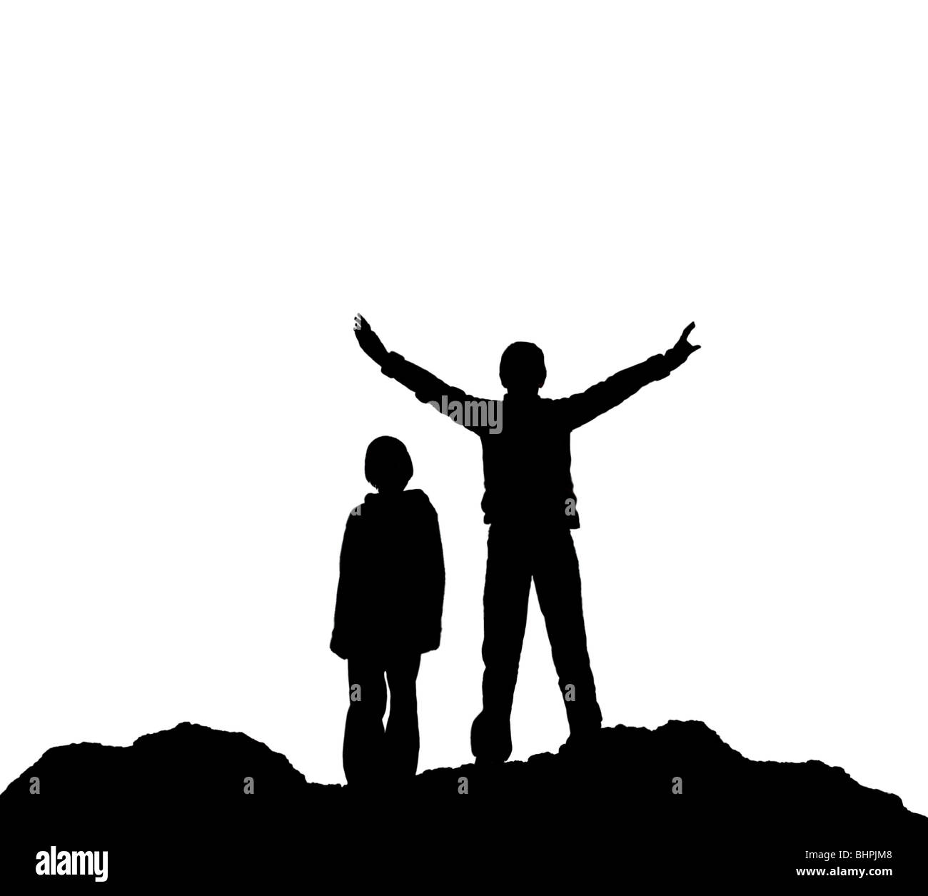 Silhouette of two children, one with arms outstretched,  standing on rough ground against a white background  - Stock Photo