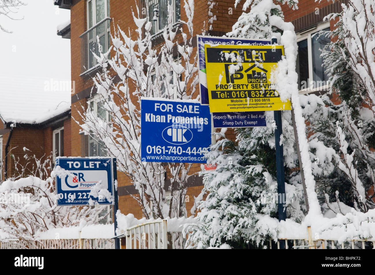 For sale and to let signs covered with snow Manchester UK Stock Photo