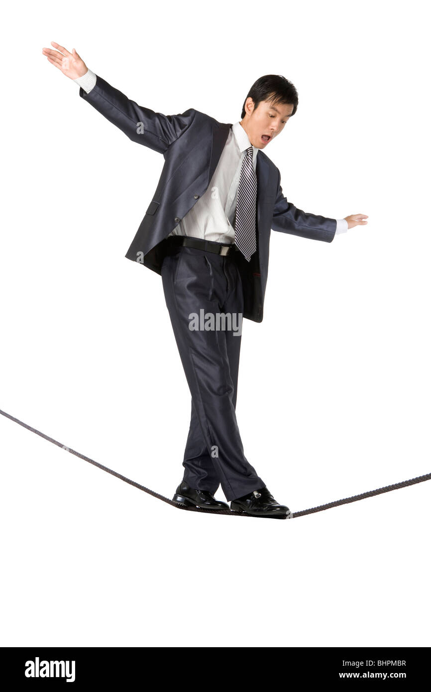 Businessman walking on rope in mid-air Stock Photo