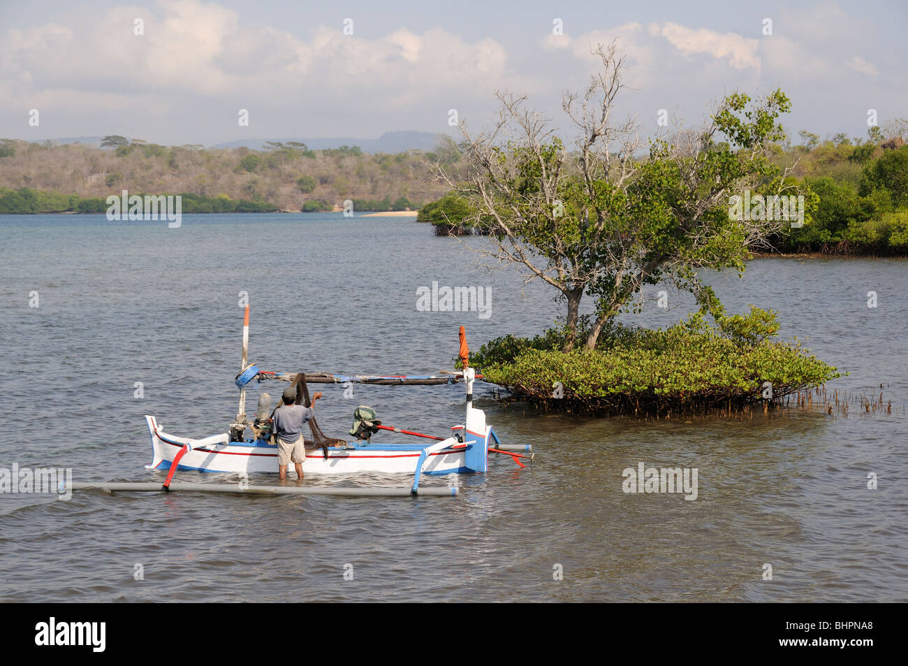 fisherman with Outrigger-Canoe in mangrove bay, Banyuwedang Bay, Bali, Indonesia, Indo-Pacific Ocean Stock Photo