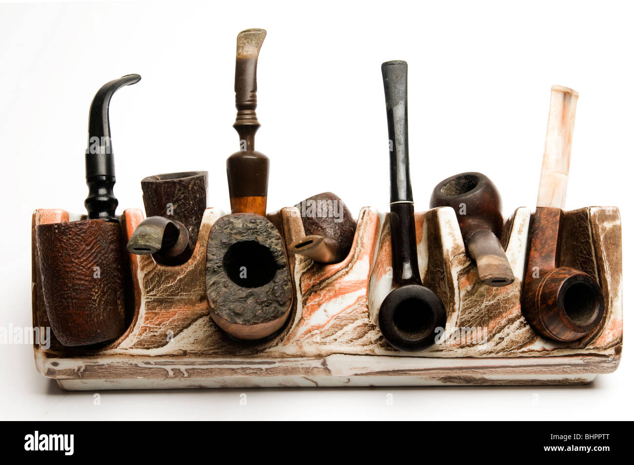 variety of pipe collection on modern pipe rack on white background Stock Photo