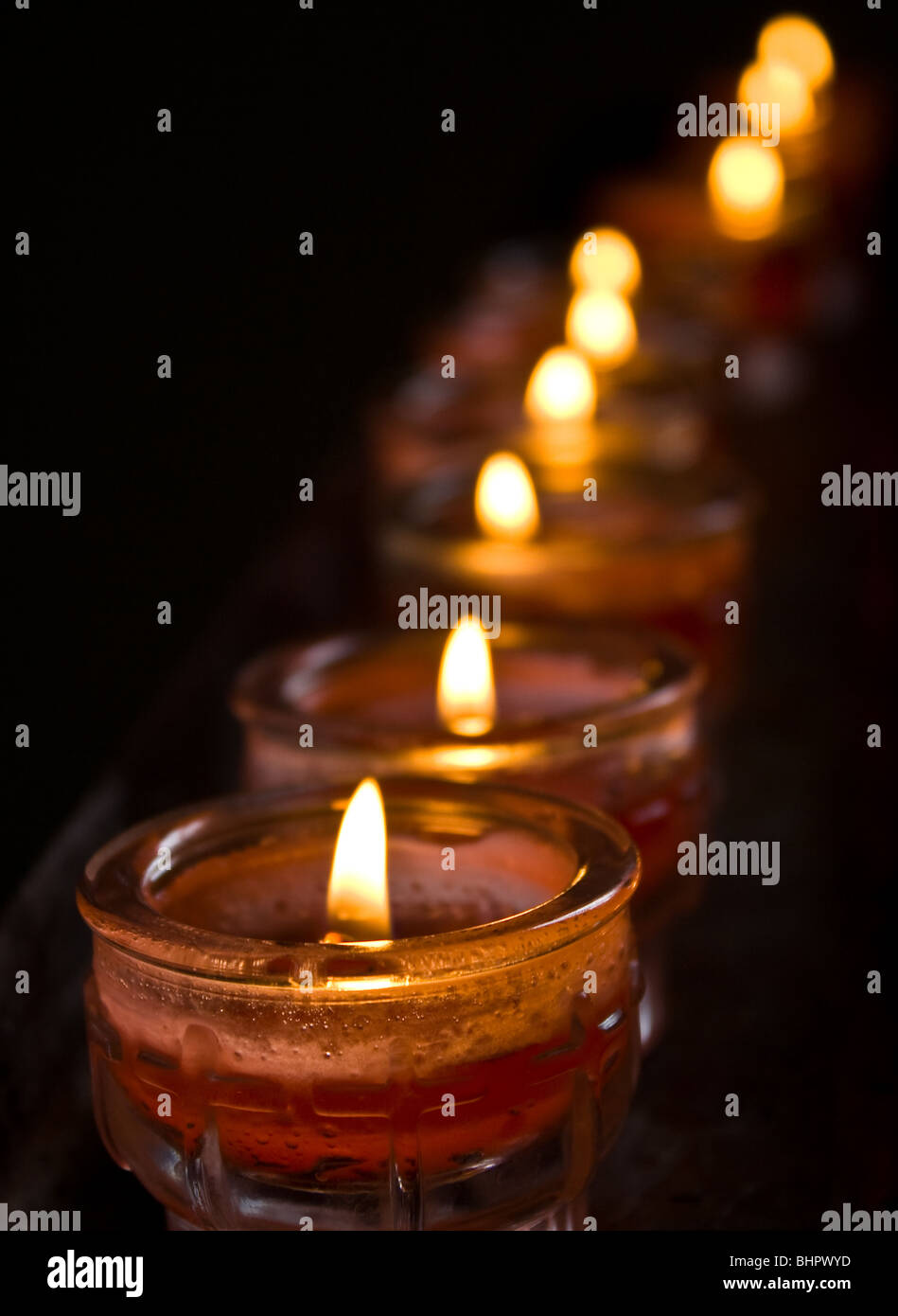 Row of candles in a dark background Stock Photo - Alamy
