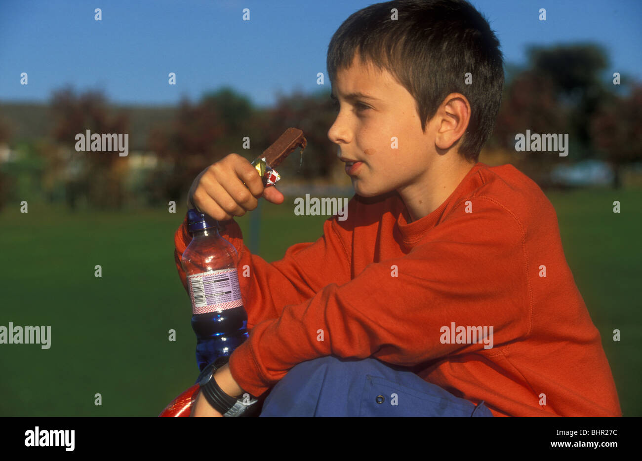 Boy eating chocolate and drinking pop Stock Photo Alamy