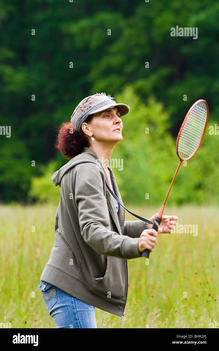 Woman with cap playing badminton in a meadow Stock Photo - Alamy