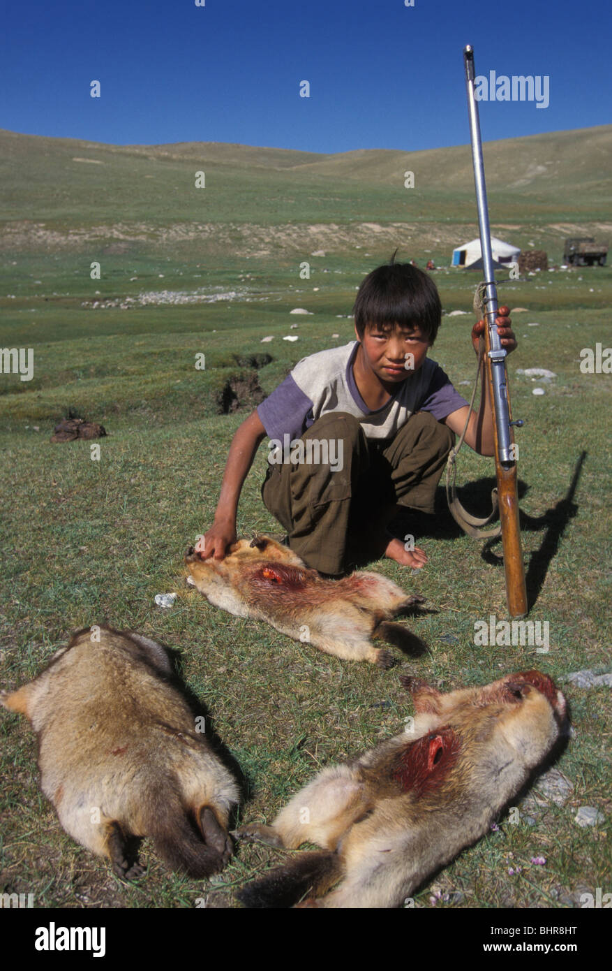 A young boy and Marmots that his father has shot , Mongolia. Stock Photo