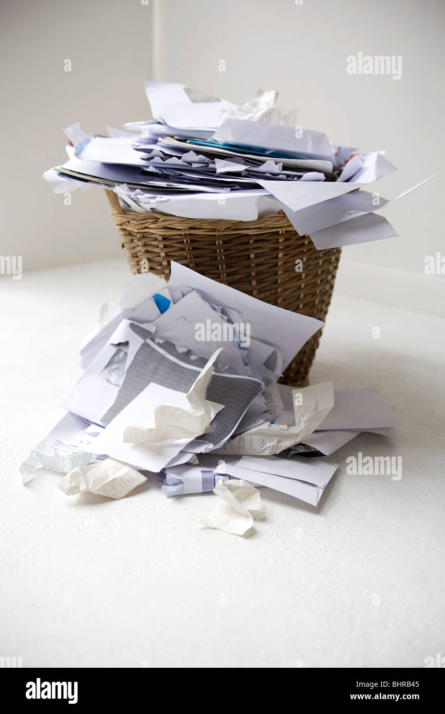 A waste paper basket full of paper Stock Photo